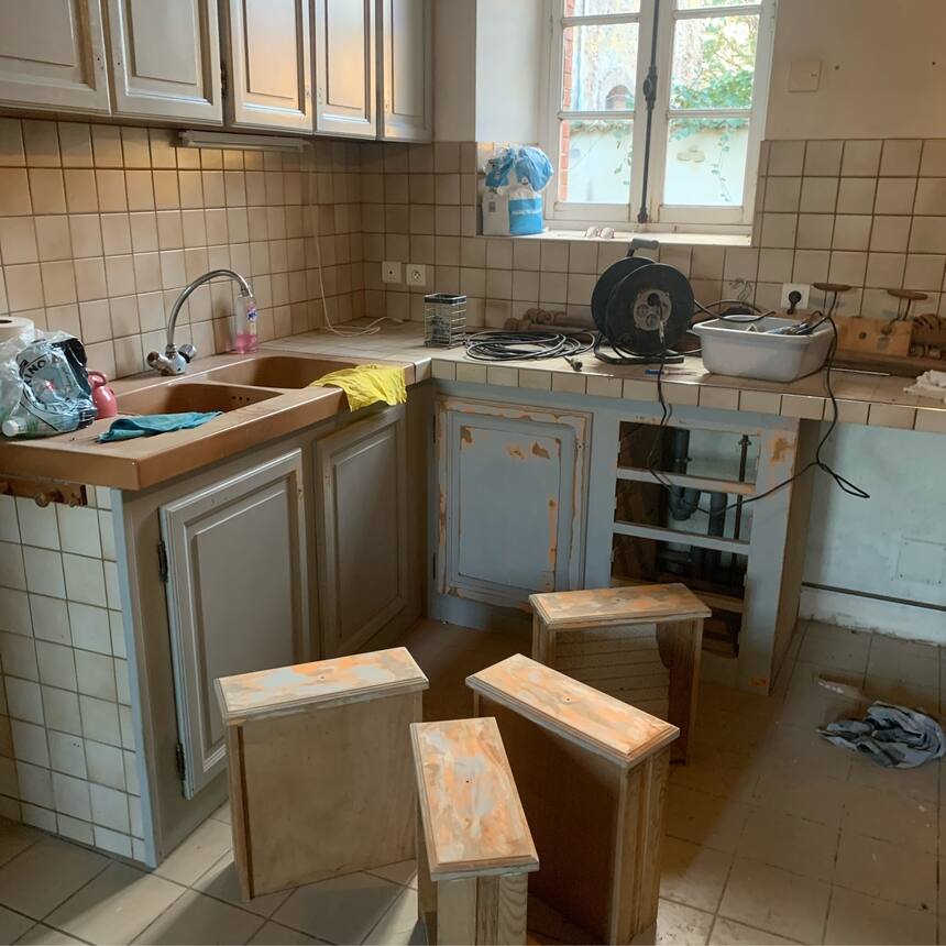 Sanding down the cabinets in the kitchen of the gite.  Yes it was painted coral 